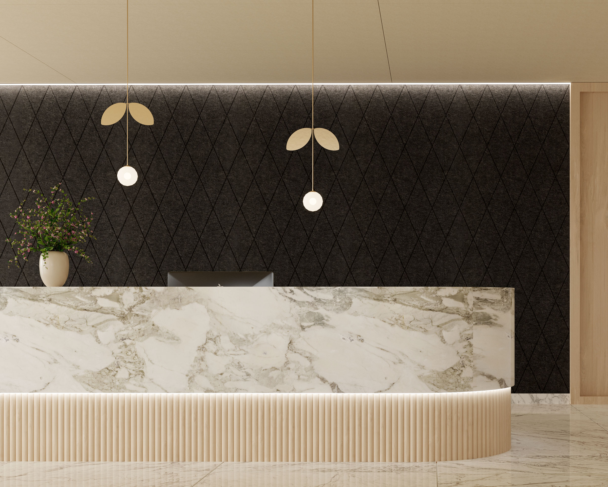 A minimalist reception area features a large marble desk with a computer monitor. Behind the desk, black acoustic felt wall panels in a diamond pattern are adorned with two modern pendant lights. A vase with a plant adds a touch of greenery to the otherwise neutral-toned space.