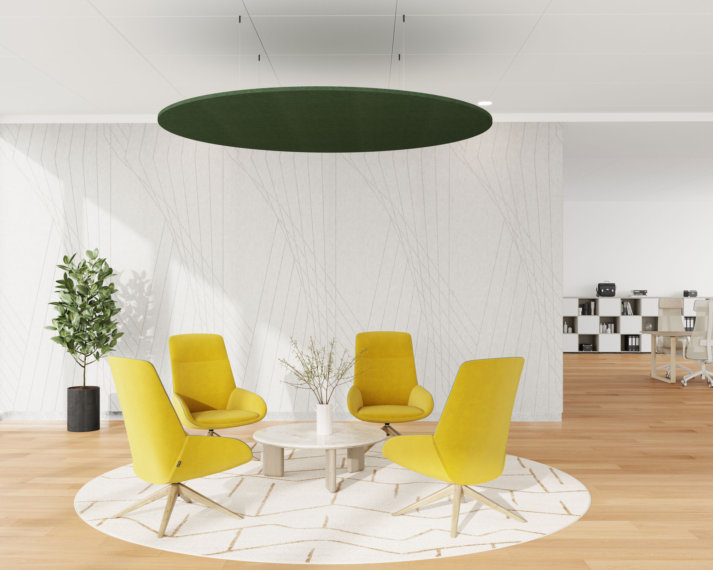 A modern office space with four yellow chairs arranged in a circle around a small round table on a white circular rug. Circle acoustic felt ceiling clouds hang above, and a potted plant sits to the left. In the background, there are shelves and a seating area with desks.