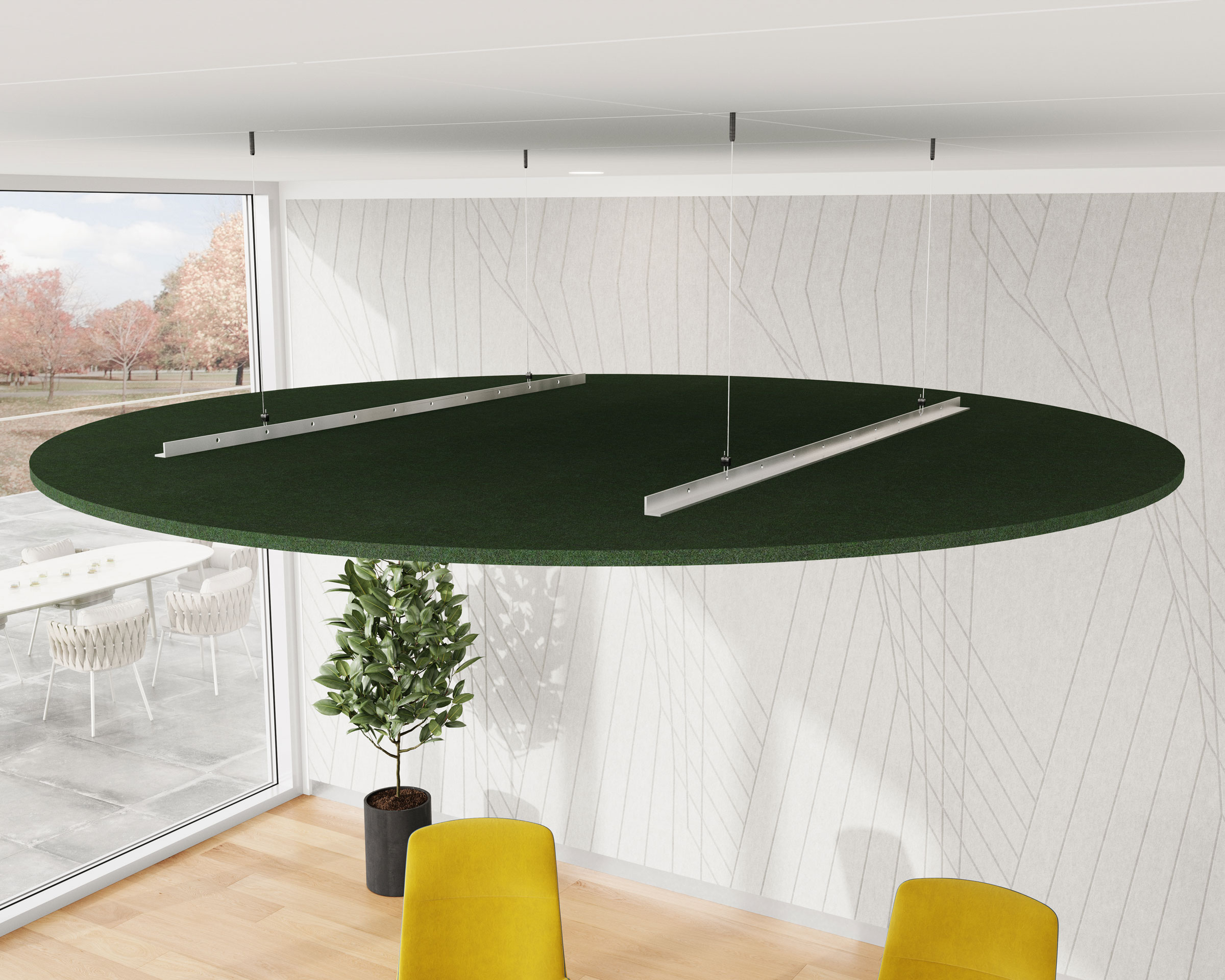 A modern interior features a large circular green acoustic felt ceiling cloud suspended from a white ceiling. The room boasts white walls with a subtle geometric pattern, light wooden flooring, two mustard yellow chairs, a potted plant, and large windows showcasing an outside patio.