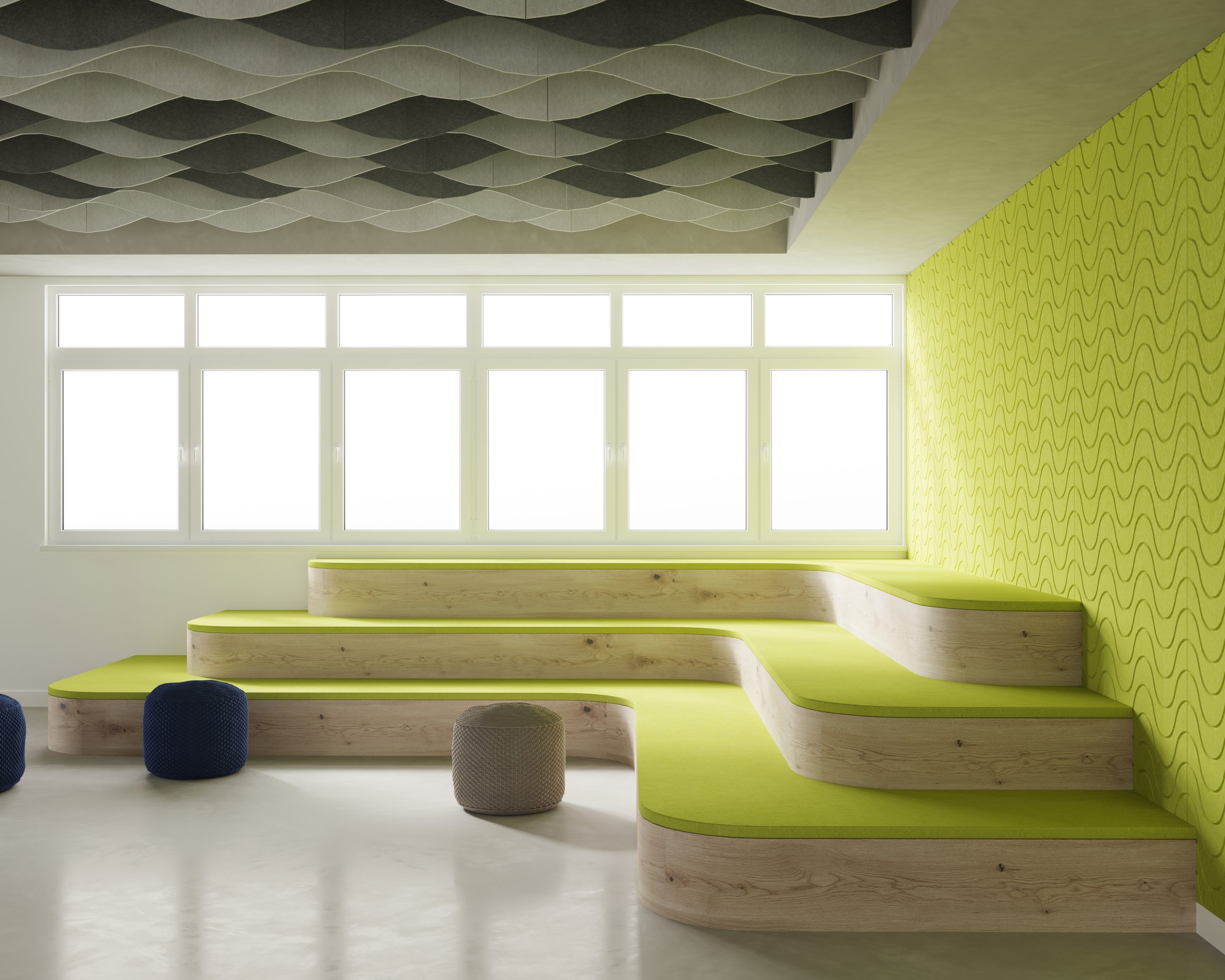 A modern, brightly lit room with tiered wooden seating, each tier topped with green cushions. The wall behind the seating features a bold, wavy yellow pattern. Blue and beige cylindrical ottomans are on the floor in front. The ceiling has gray, rippled acoustic baffles for sound control.