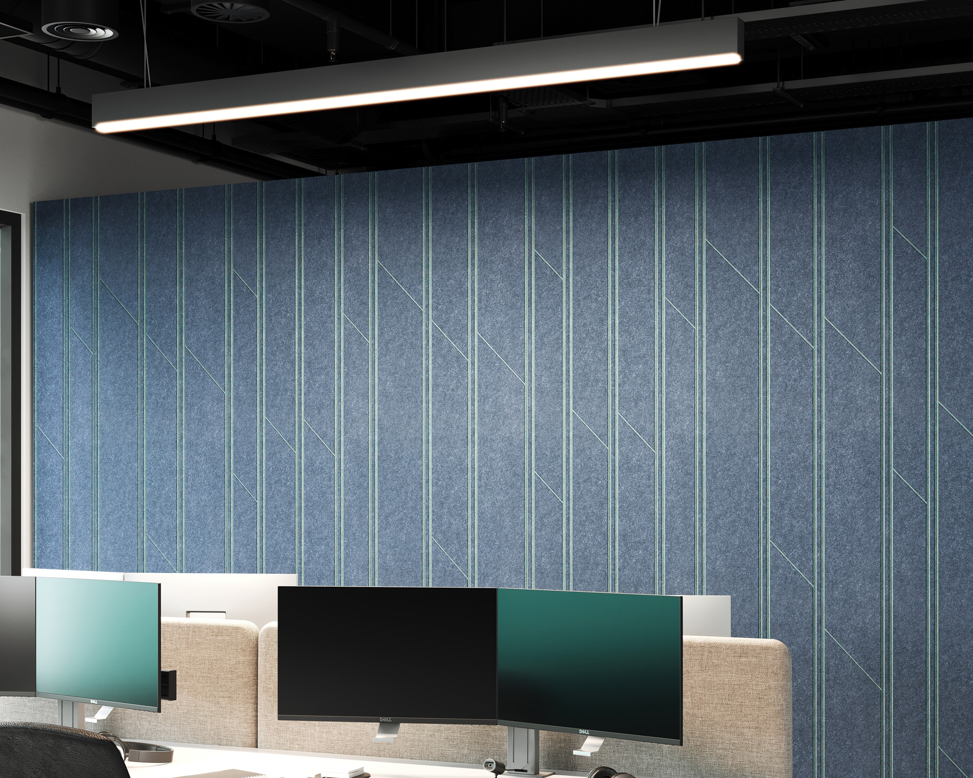 A modern office workspace with multiple computer monitors on desks. The background features an acoustic felt wall panel adorned with stylish, blue geometric patterns. Overhead, a sleek, linear LED light fixture hangs from a dark, exposed ceiling.