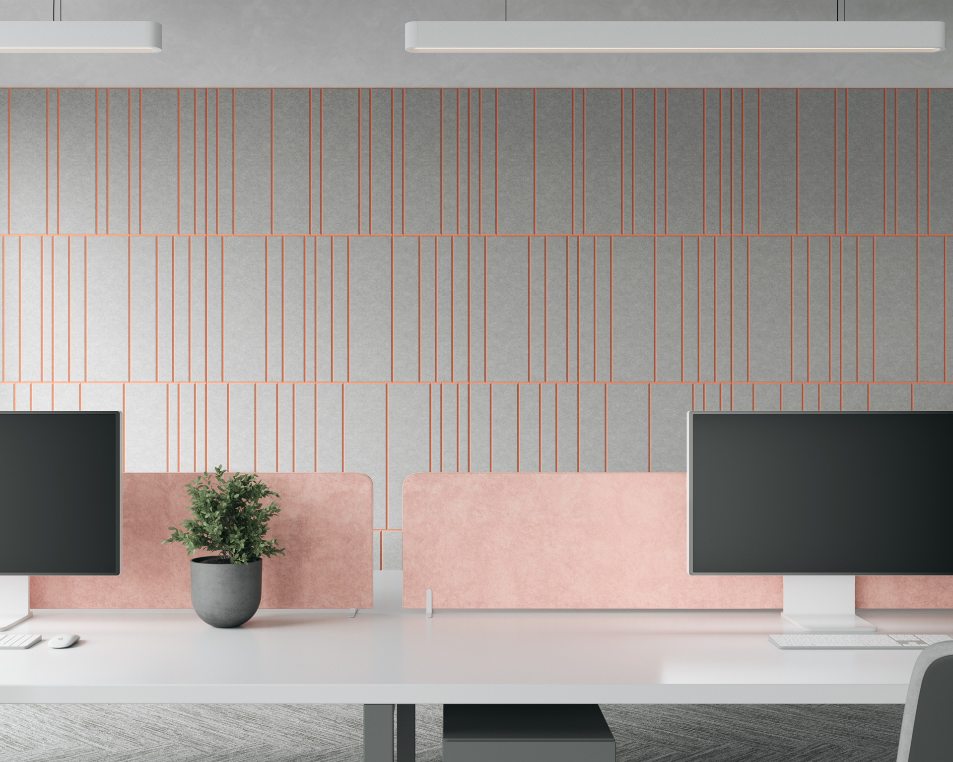 A modern office space featuring two workstations. Each desk has a monitor and is separated by pink privacy panels. A potted plant sits on one desk. The back wall, adorned with an acoustic felt wall panel, showcases a geometric design with vertical pink lines on a grey background.