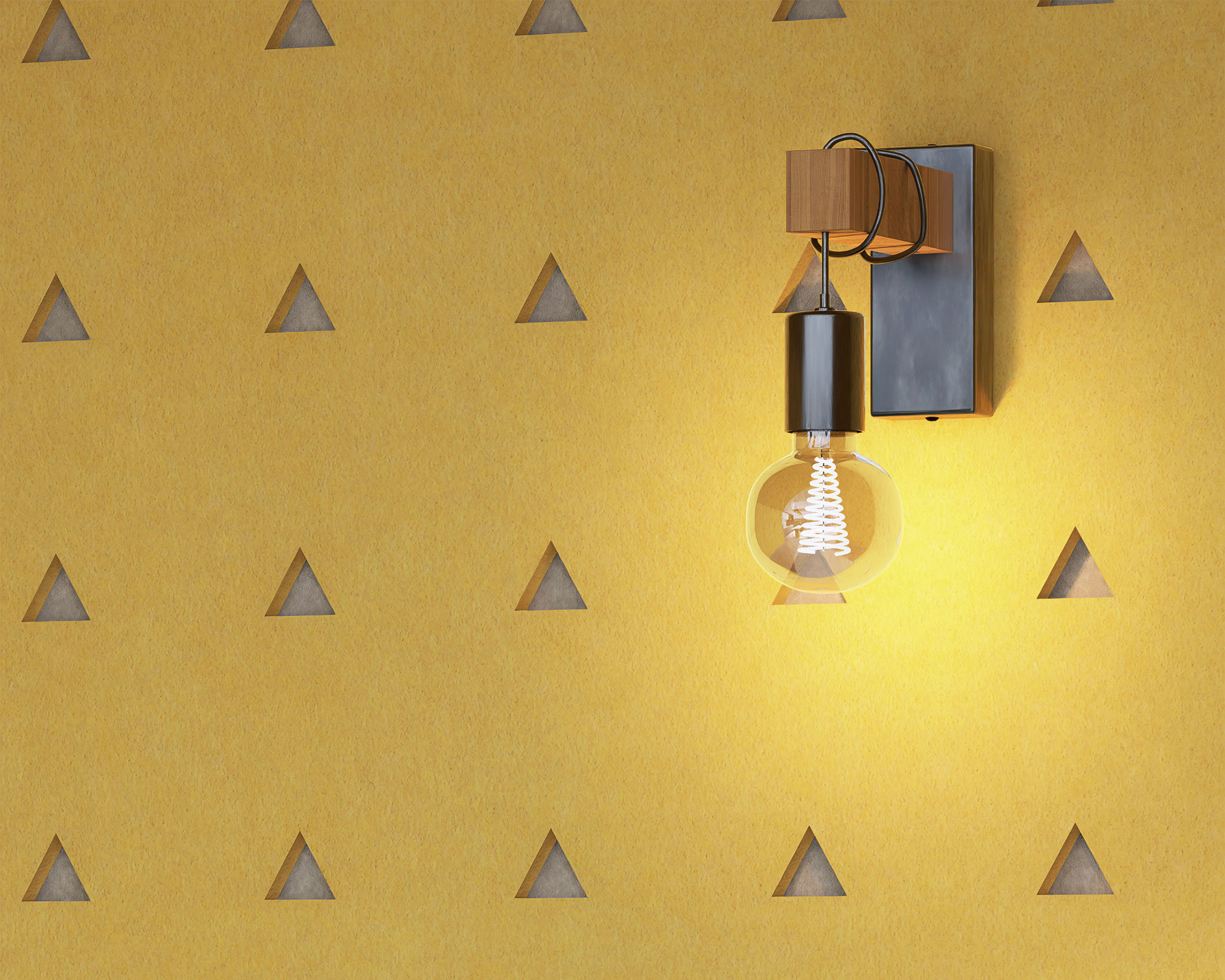 A modern wall lamp with an exposed bulb is mounted on a yellow wall featuring triangle acoustic felt wall panels. The lamp is lit, radiating a warm glow that highlights the texture and design of the wall.