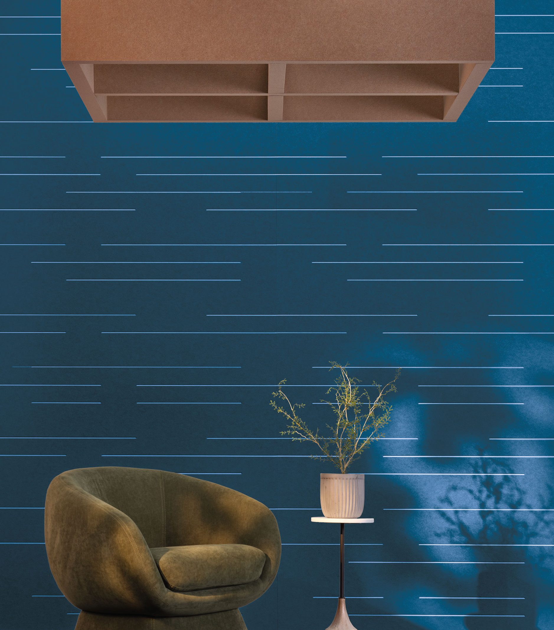 A modern interior featuring a moss green armchair, a small round table with a potted plant, and a blue wall with horizontal white lines creating a sleek design. A large brown rectangular ceiling fixture from our premier collection hangs above, adding an exceptional touch.