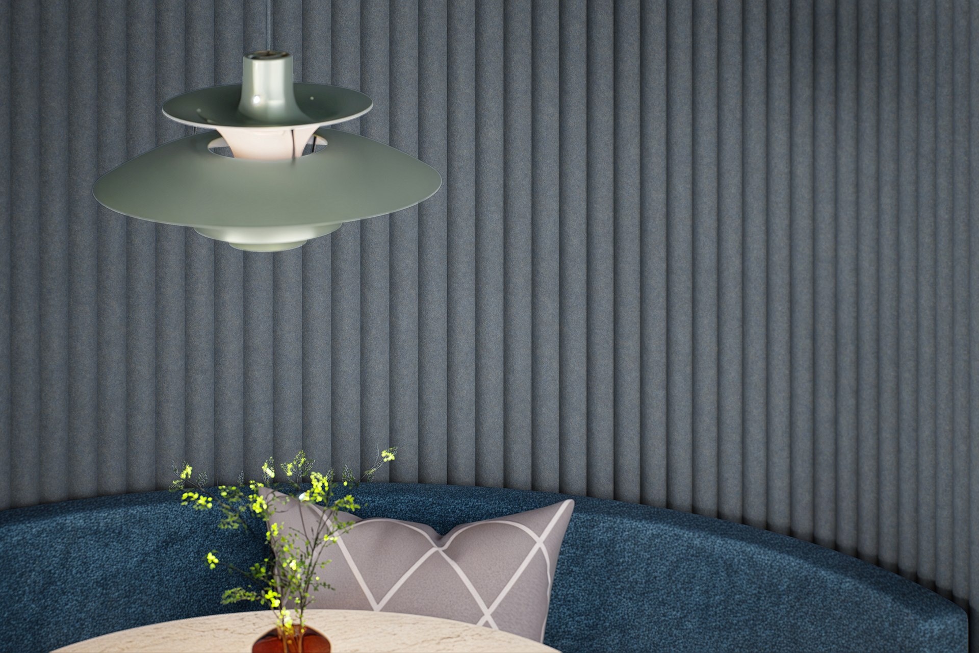 A modern interior features a hanging green pendant lamp above a round, pale table. A blue cushioned seating area with a gray pillow and a small vase with yellow flowers is in front of a textured, dark wall with vertical lines.