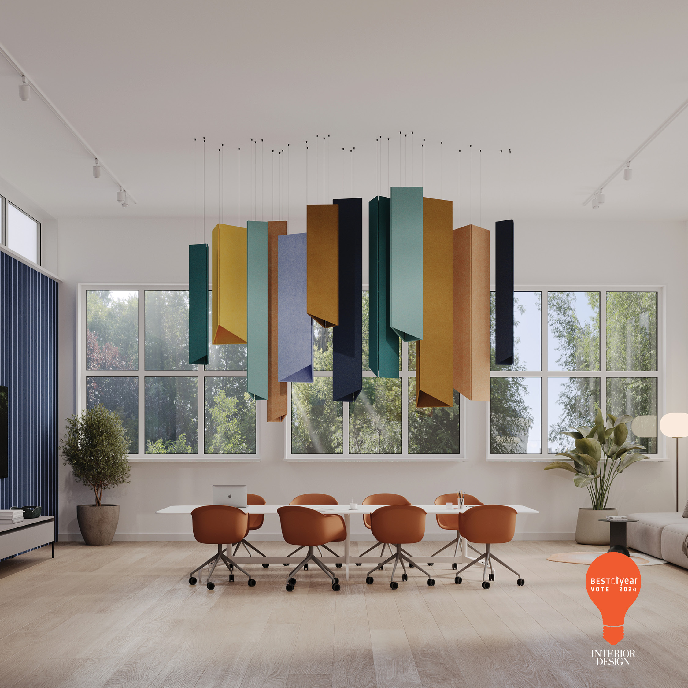 A modern conference room with large windows, natural light, and a colorful geometric ceiling fixture. There's a round white table surrounded by brown chairs, and a plant in the corner. Best of Year Interior Design badge is displayed.