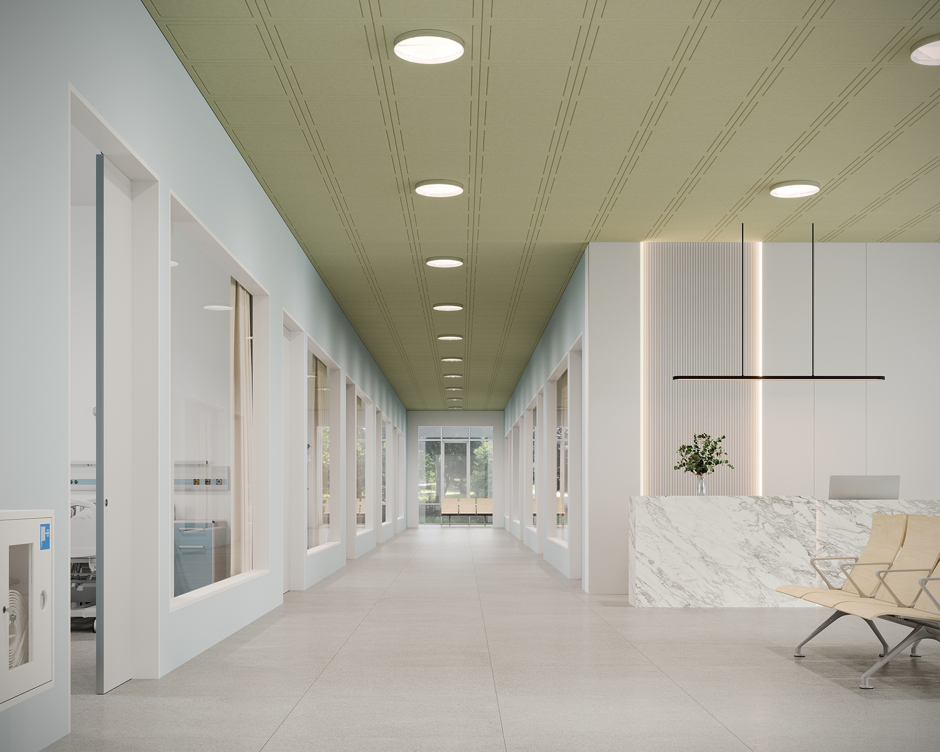 A bright, modern hallway features a green acoustic felt ceiling with circular recessed lights and light gray flooring. On the right, a marble-fronted reception desk is adorned with a plant and chairs. Large windows on the left allow natural light to flood in.