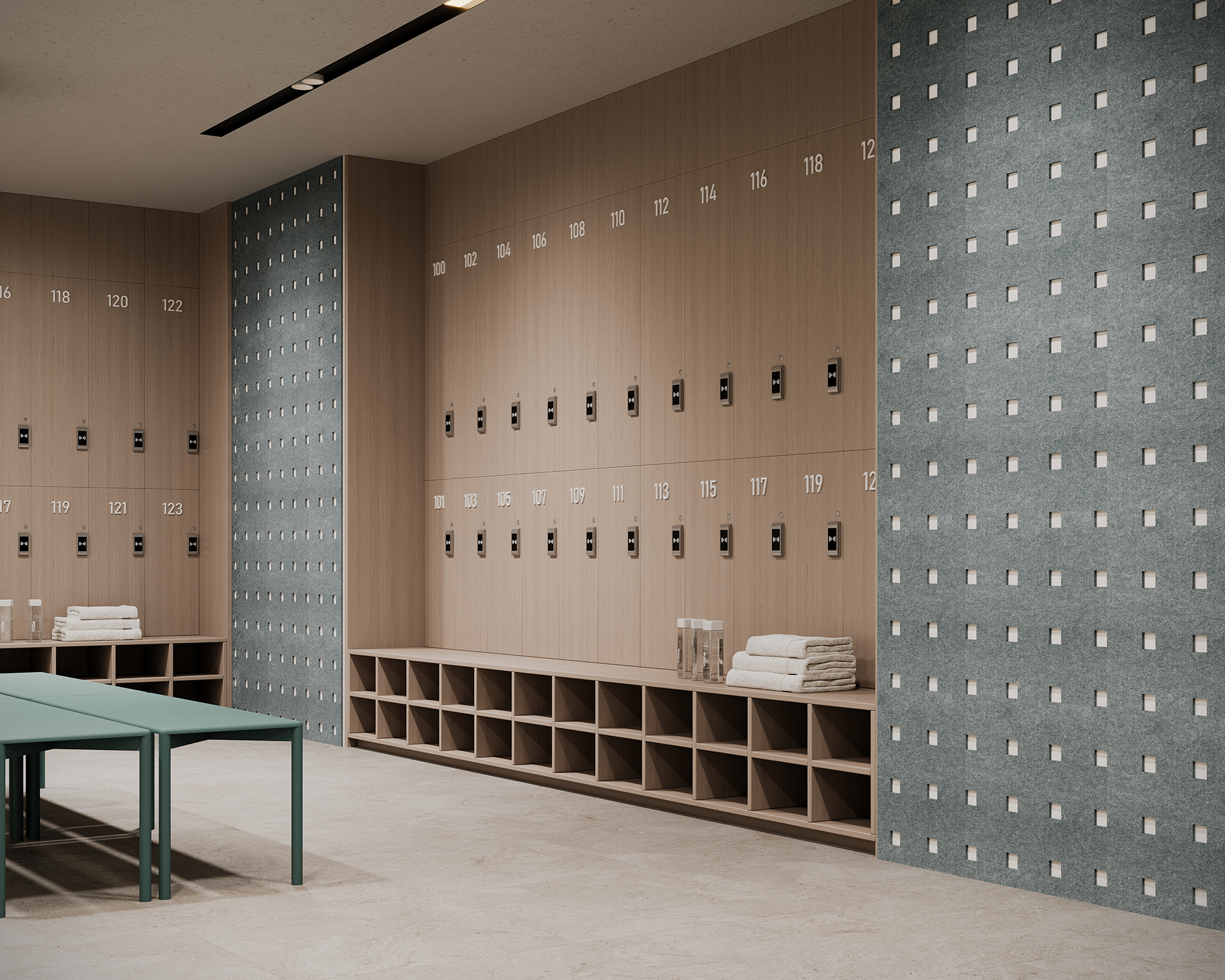 Modern locker room with wooden lockers numbered 112 to 122, a bench in the foreground, folded towels, and a textured acoustic felt wall with small square patterns. The space appears clean and organized.