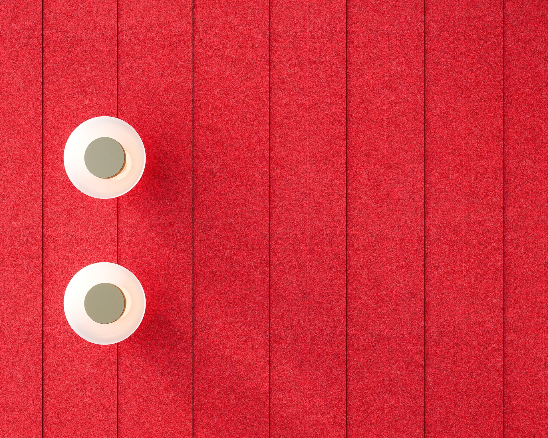 Two white circular lights are mounted on a vibrant red, horizontally paneled acoustic felt wall. The lights are aligned vertically on the left side, contrasting with the textured background.