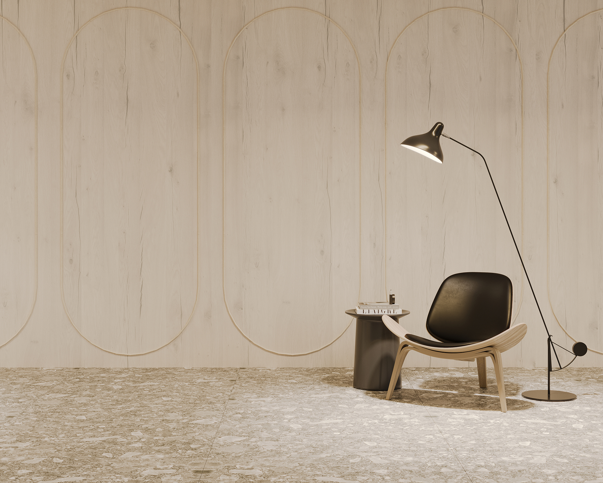 Minimalist room with a light wood-paneled wall featuring oval patterns. A black, sleek chair sits beside a small round table holding books and a candle. A tall, modern floor lamp curves overhead, casting light on the setup. Grey speckled flooring.