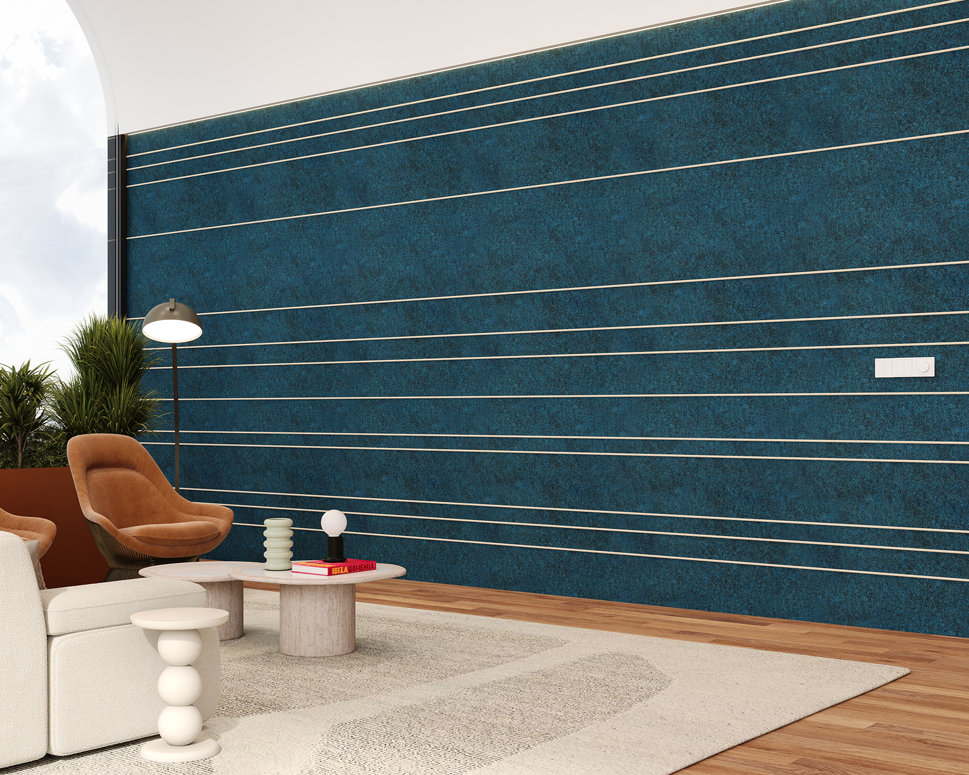 A modern living room features a large teal acoustic felt wall with horizontal metal lines. There's a white sofa, a brown chair, a round wooden coffee table with decor, and a white floor lamp. Potted plants are by the arched window, enhancing the cozy ambiance.